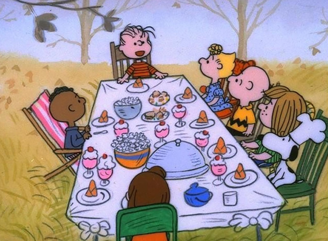Charlie Brown and Friends sit around a Thanksgiving table. 